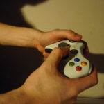 A gamer holding an Xbox 360 controller.